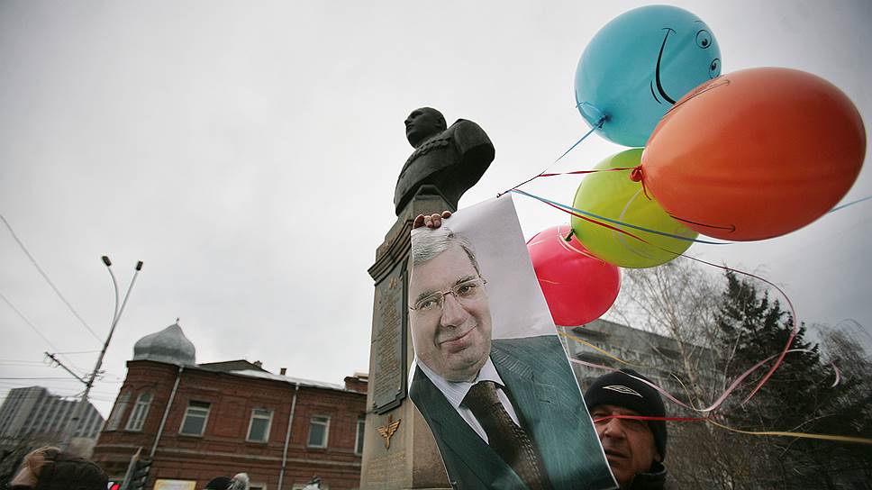 Митинг обманутых дольщиков и инвесторов ЖСК «Свой дом» по ул. Тульская, 84. Мужчина держит в руках плакат с портретом полпреда президента в СФО Виктора Толоконского 06.04.2011 