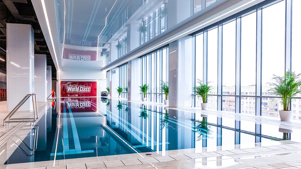 Современный 27-метровый бассейн с панорамным видом и отличной зоной релакса с шезлонгами и столиками для заказов из фитнес-бара – одно из главных преимуществ премиального спортивного клуба World Class