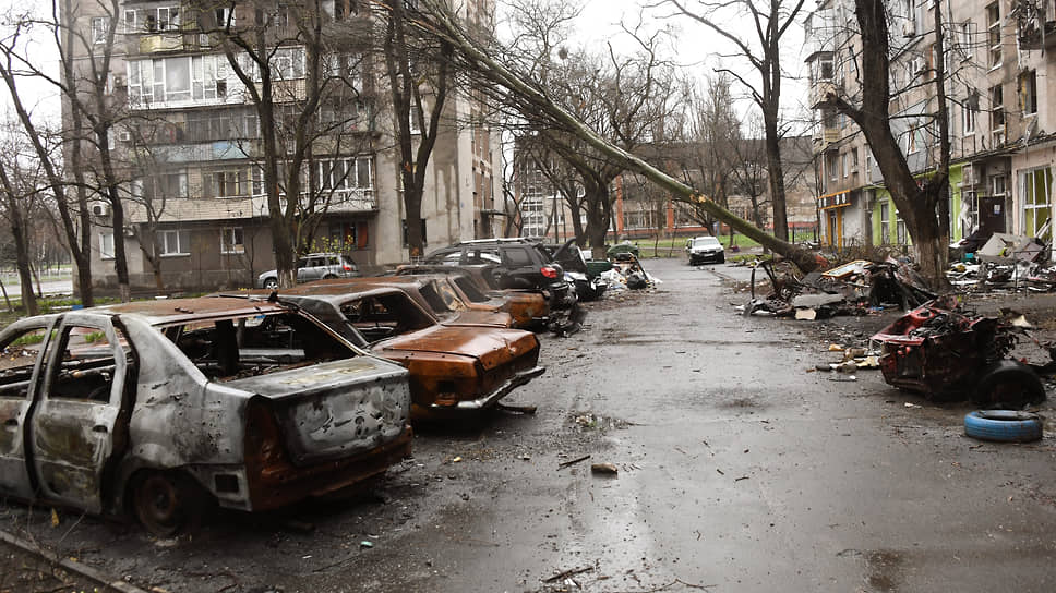 Разбитые и сожженные автомобили на парковке возле жилого дома  в Левобережном районе Мариуполя