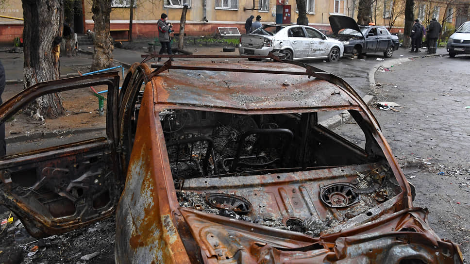 Искореженный после обстрела автомобиль во дворе жилого дома в Левобережном районе Мариуполя