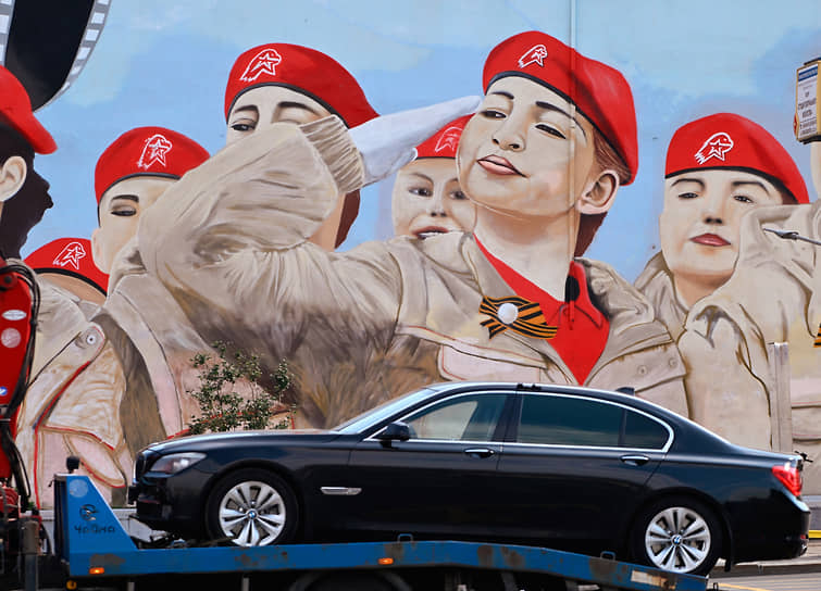 BMW 7 Серии увозят на эвакуаторе на фоне мурала с изображением юнармейцев в Москве 