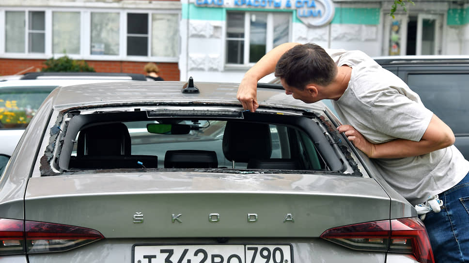 Владелец осматривает выбитое стекло багажника своего автомобиля, поврежденного в процессе ликвидации двух беспилотников в Красногорске 