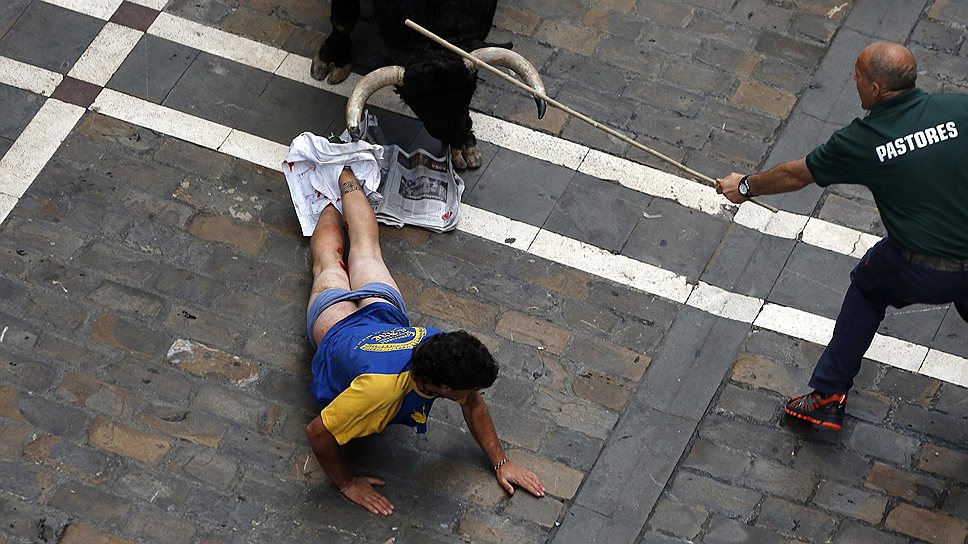 12 июля. Бык атакует одного из участников традиционного «бычьего» забега на фестивале «Сан-Фермин» в Памплоне, Испания