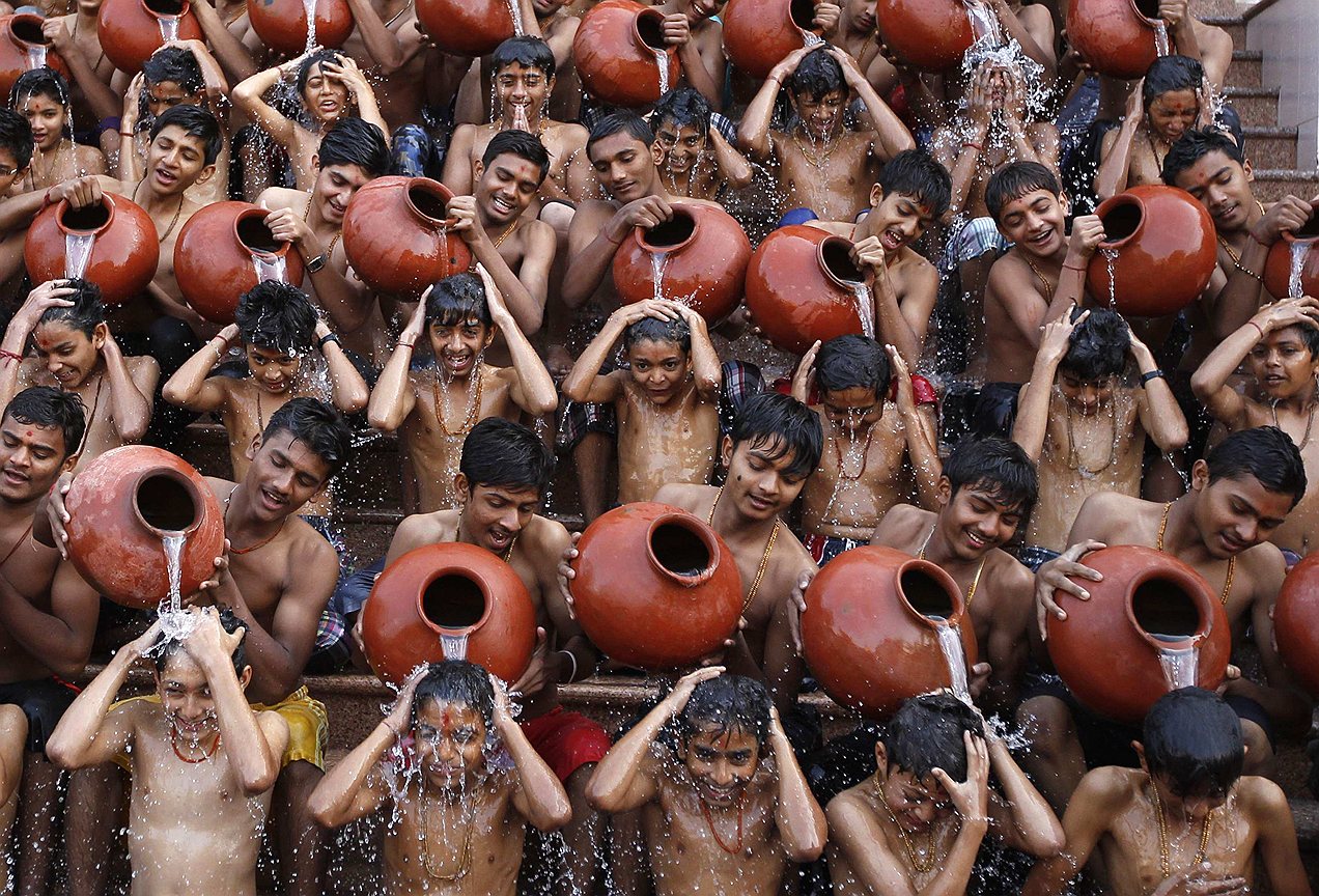 Индийские студенты поливают друг друга водой, совершая священное омовение на праздник Магхи Пурнима в Ахмедабаде