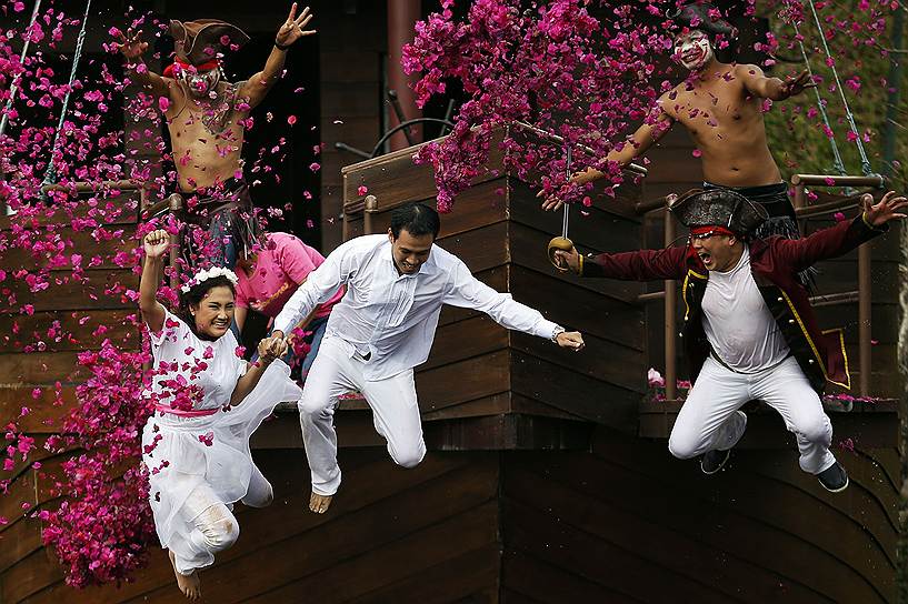 Жених и невеста прыгают в пруд, спасаясь от &quot;пиратов&quot; во время свадебной церемонии в Таиланде