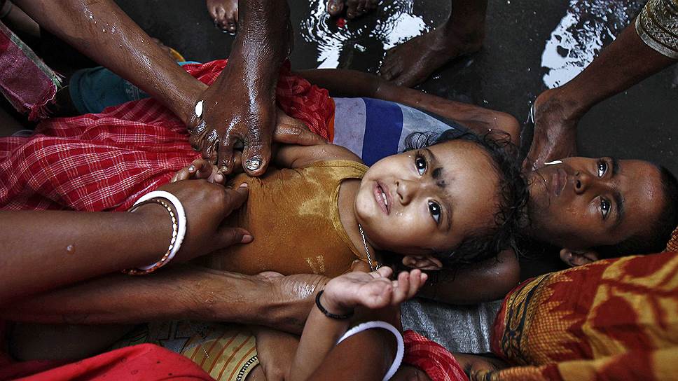 Благословение ребенка на религиозном фестивале Гаджан в Индии