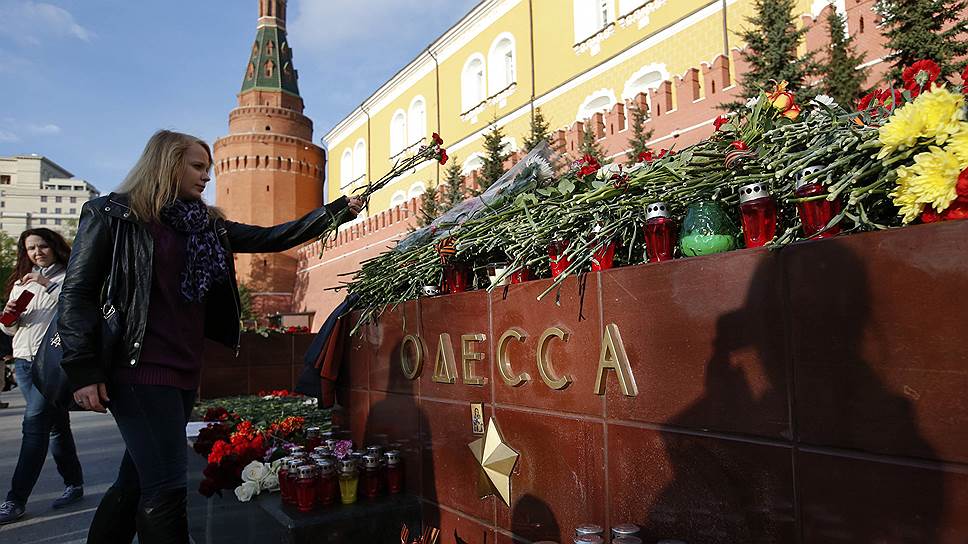Женщина возлагает цветы к мемориалу Одессы на Красной площади, Москва, Россия, после гибели более 40 человек при пожаре в местном Доме профсоюзов