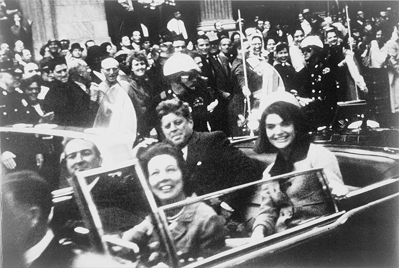 21 ноября 1963 года Кеннеди с женой отправился в рабочую поездку по Техасу в поддержку предвыборной кампании 1964 года. 22 ноября президентская чета поехала в кортеже в Торговый Аукционный зал, где Джон Кеннеди должен был выступить с речью во время обеда. Супруги Кеннеди (на двух задних сиденьях) и губернатор Техаса Джон Конналли с женой Нелли (на двух передних), ехали в кабриолете ближе к голове кортежа. На Элм-Стрит, в 12.30 по местному времени, Кеннеди был смертельно ранен выстрелом из винтовки. Журналисты так описывали его визит в Даллас: «Господина Кеннеди приветствовали восторженные жители, несмотря на предсказания о том, что в Далласе — этой цитадели правого республиканства — президенту будет оказан холодный прием»