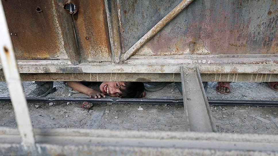 Сирийский мальчик подсматривает за разгрузкой гуманитарной помощи на складе «Красного полумесяца» в Гуте неподалеку от Дамаска
