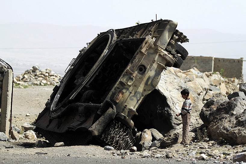 Мальчик возле уничтоженного танка в провинции Омран, Йемен