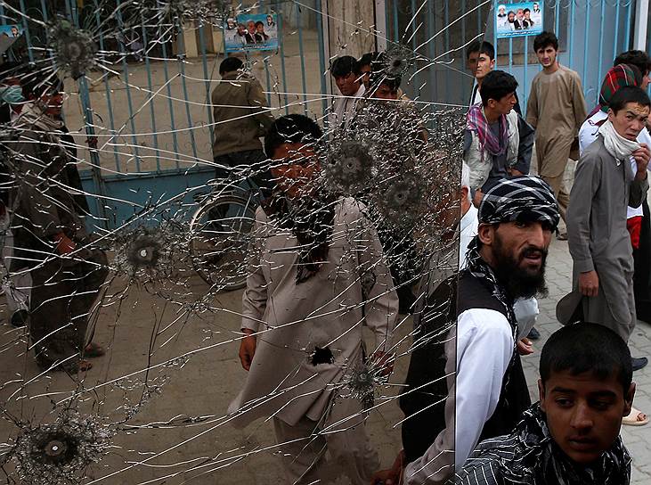 Афганцы осматривают автобус, поврежденный при взрыве бомбы в Кабуле