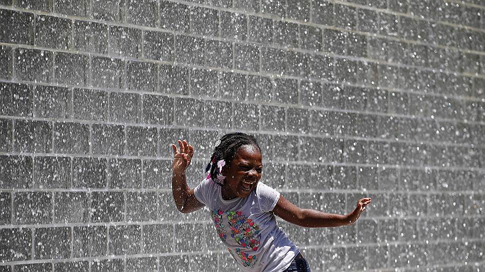 Девочка танцует под струями фонтана в Чикаго