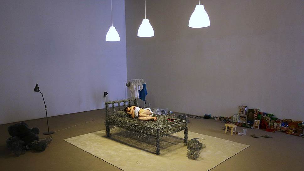 Китайский художник дремлет на кровати из колючей проволоки — одной из своих инсталляций в галерее Beijing Now Art