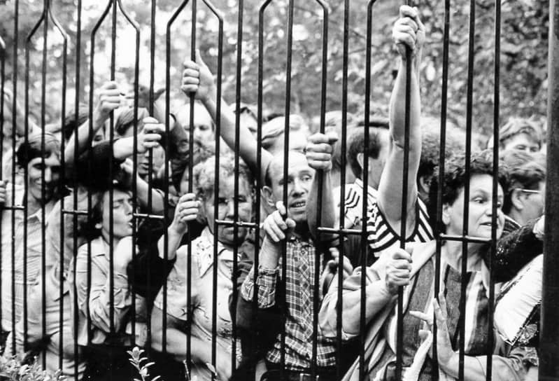 Толпа у металлической ограды, 1980 год