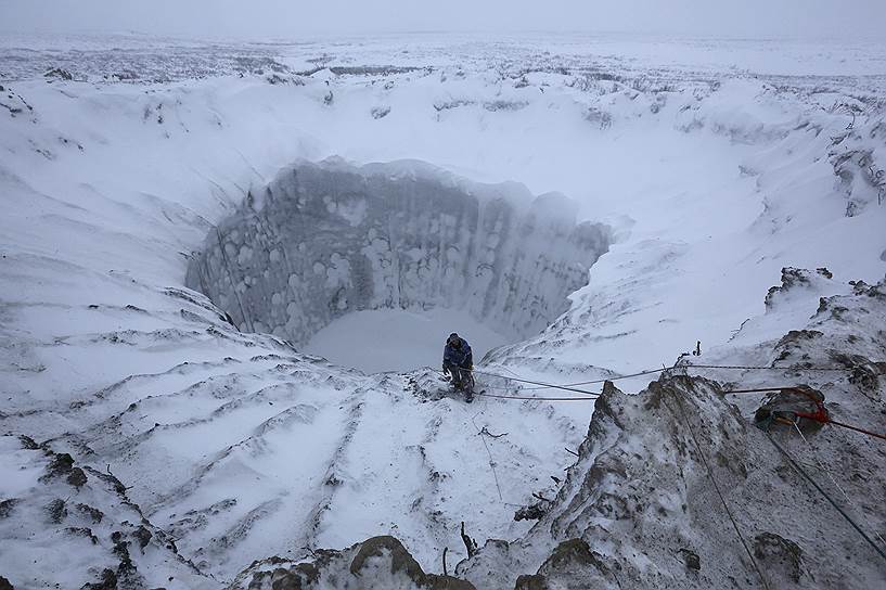 Полуостров Ямал, Россия. Член экспедиционной группы, состоящей из исследователей и ученых, на краю кратера неизвестного происхождения, открытого летом при помощи аэрофотосъемки