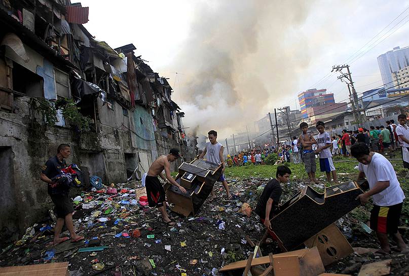 Манила, Филиппины. Семьи выносят свои вещи из горящих домов в трущобах