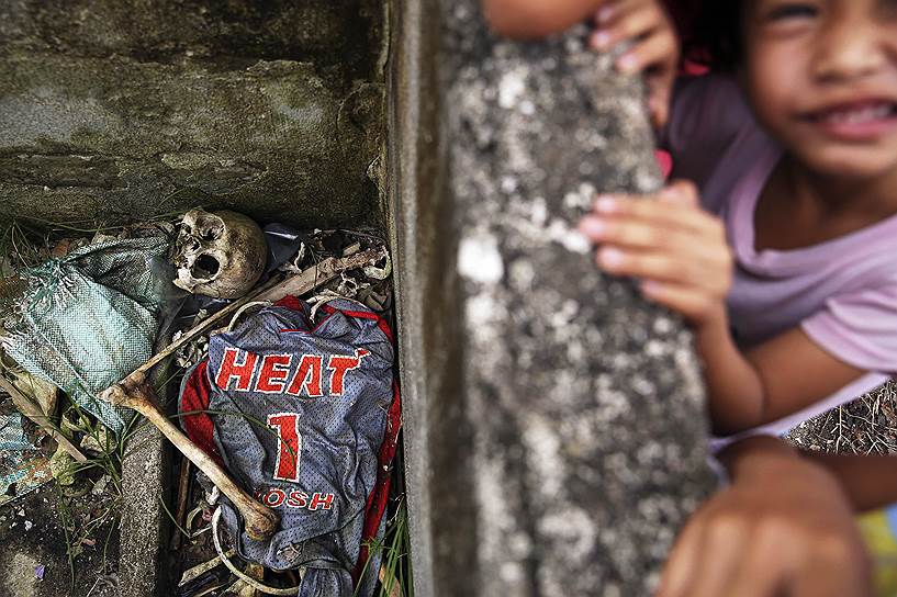Таклобан, Филиппины. Дети играют в руинах возле человеческих останков, в прибрежной части города, который пострадал от урагана Хайян