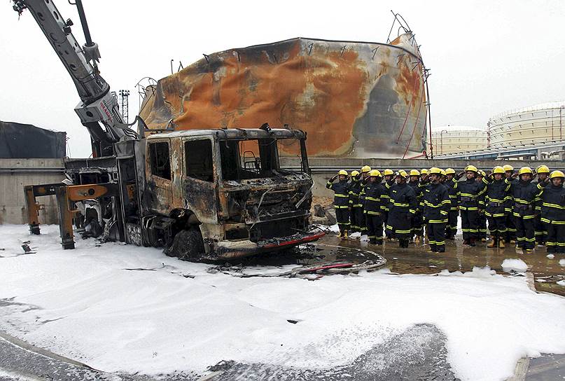Чжанчжоу, Китай. Пожарные отдают честь спецавтомобилю, сгоревшему при тушении пожара на химическом заводе Dragon Aromatics