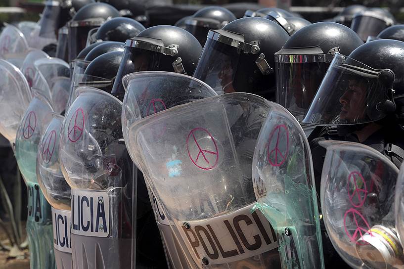 Манагуа, Никарагуа. Символы мира, нарисованные на щитах полиции во время митинга за честные выборы