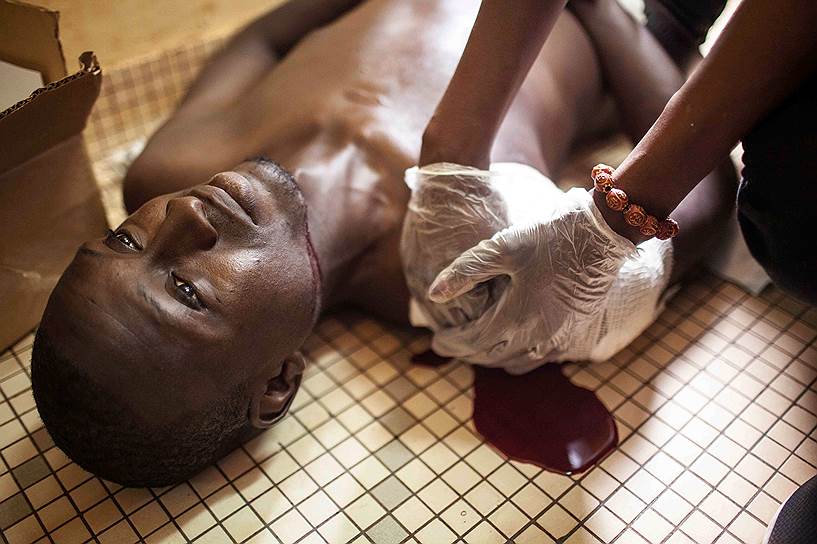 Уагадугу, Буркина-Фасо. Оказание помощи демонстранту, раненному во время беспорядков в столице, вызванных военным переворотом. Позже этот мужчина скончался