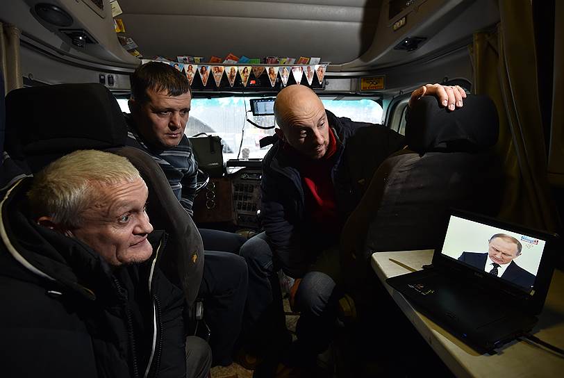 Участники акции дальнобойщиков «Платон» на трассе «Москва — Санкт-Петербург» смотрят в кабине грузового автомобиля ежегодное послание президента 