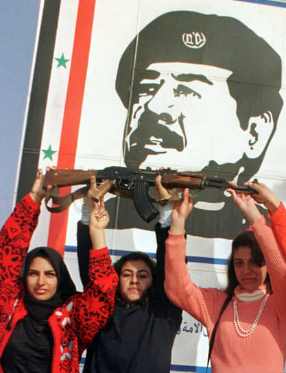 Иракские женщины-добровольцы на фоне плаката с изображением президента Ирака Саддама Хусейна в багдадской школе. 1998 год 
