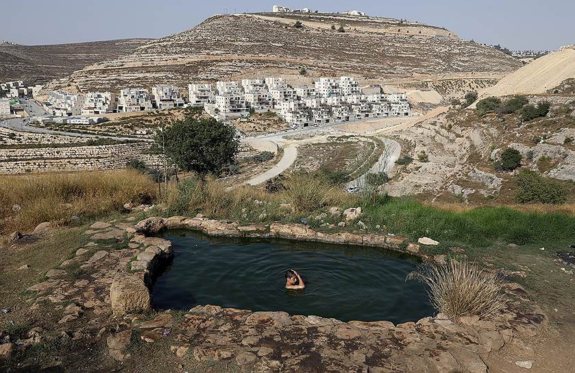 Иерусалим, Израиль. Молодые люди плавают в озере в жаркий летний день