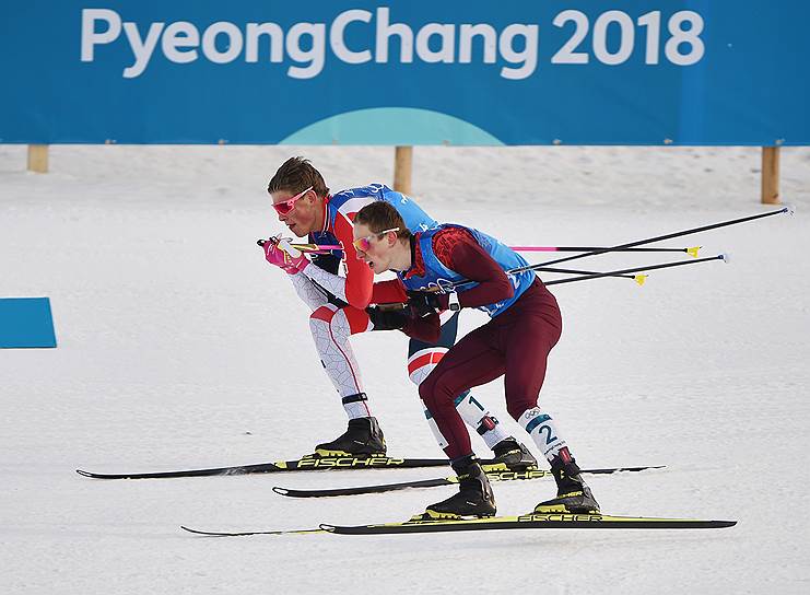 Российский спортсмен Денис Спицов (справа) и норвежский спортсмен Йоханнес Хесфлот Клебо во время эстафеты по лыжным гонкам
