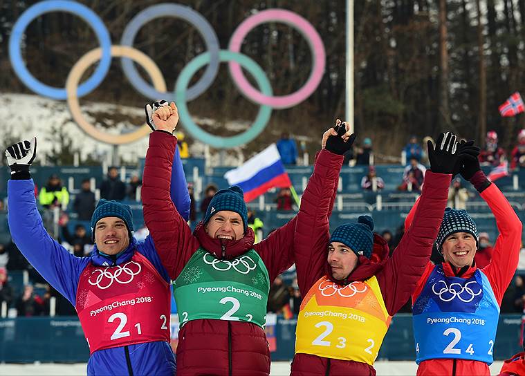 Слева направо: российские лыжники Андрей Ларьков, Александр Большунов, Алексей Червоткин и Денис Спицов во время церемонии награждения победителей с серебряными медалями