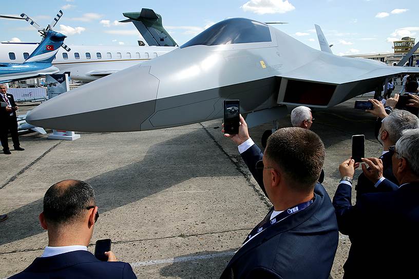 Посетители выставки фотографируют макет турецкого истребителя производства Turkish Aerospace