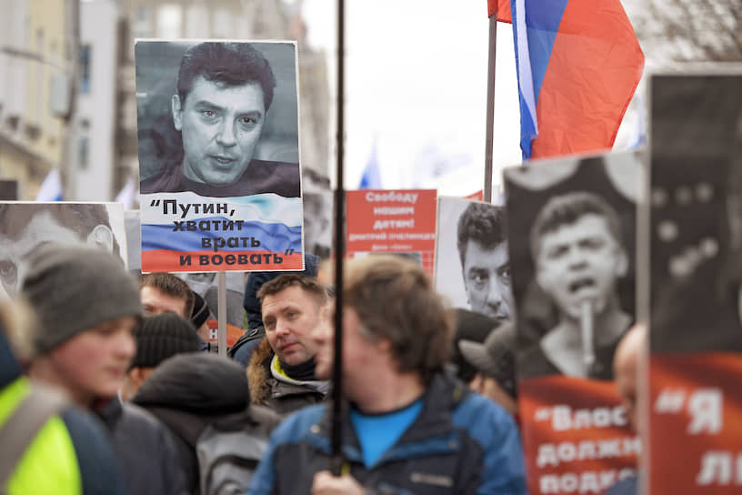 Участники марша памяти Бориса Немцова в Москве несут плакаты с цитатами политика