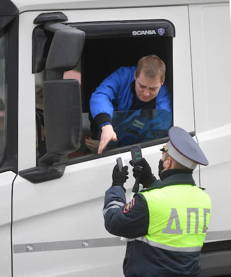 Сотрудник ДПС проверяет у водителя пропуск при въезде в Москву на Ленинградском шоссе