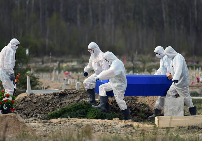 Санкт-Петербург. Сотрудники Нового Колпинского кладбища в защитных костюмах несут гроб с телом умершей от COVID-19 к могиле 