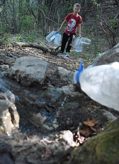 Село Верхняя Кутузовка, Крым. Местные жители набирают воду в горном роднике 