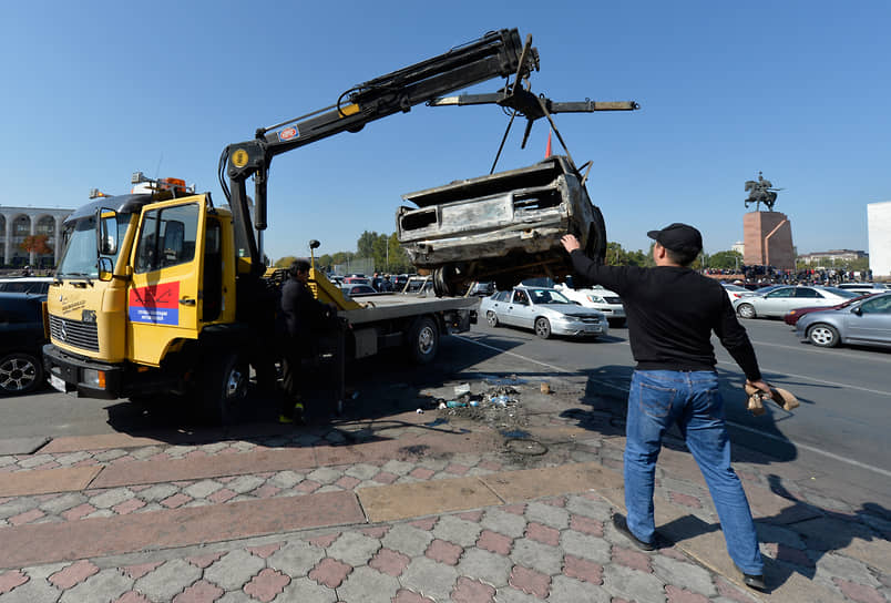 Эвакуатор забирает сожженную машину в центре Бишкека