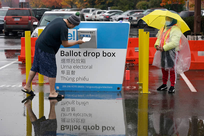 Рентон, Вашингтон. Избиратель опускает свой бюллетень в урну для голосования