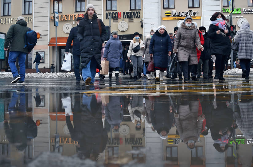 Москва, Россия. Прохожие идут по лужам 