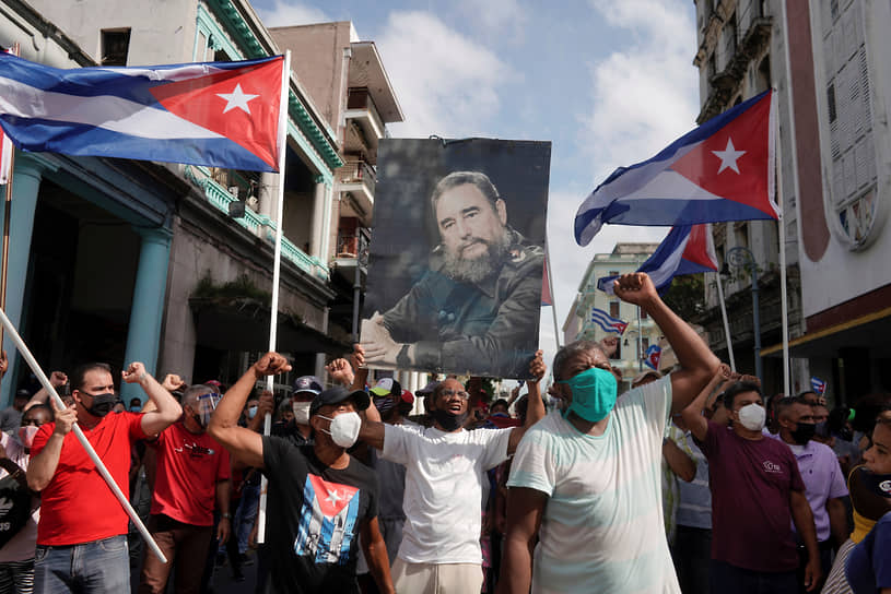 Сторонники правительства держат фотографию покойного кубинского лидера Фиделя Кастро