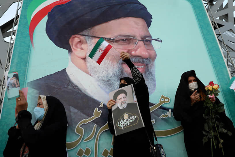 Сторонники избранного президента Ирана Эбрахима Раиси на фоне его портрета