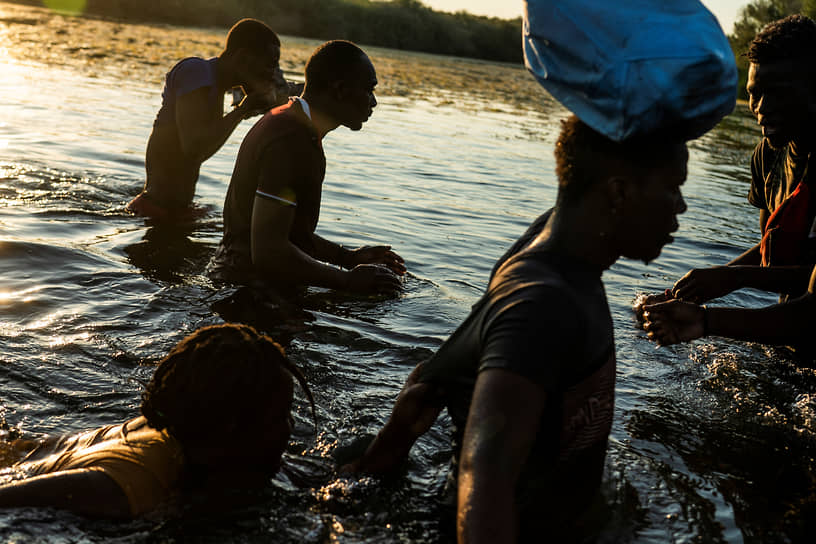 Сьюдад-Акунья, Мексика. Мигранты переходят в брод реку Рио-Гранде на границе с США
