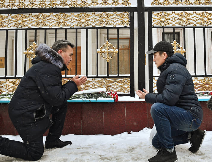 Люди во время возложения цветов к посольству Казахстана