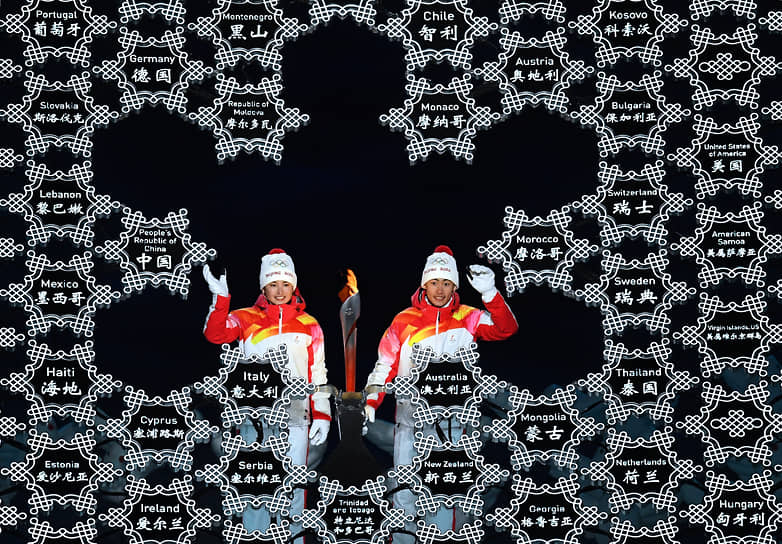 Спортсмены олимпийской команды КНР Динигер Иламуцзян и Цзявен Чжао во время зажжения чаши олимпийского огня на церемонии открытия