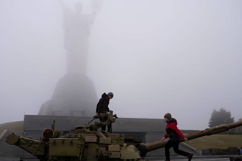 Дети играют на танке, установленном в качестве памятника в Киеве