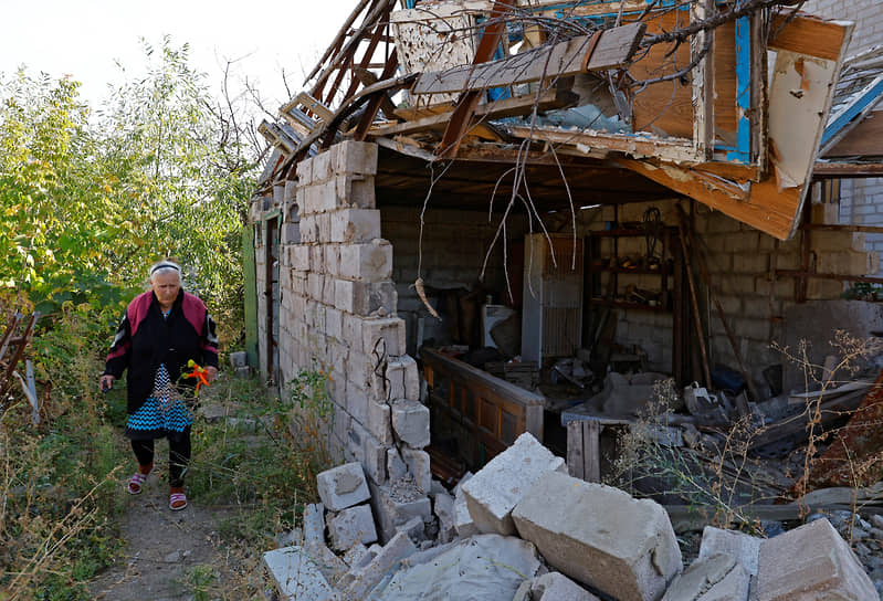 Жительница Мариуполя у своего разрушенного дома