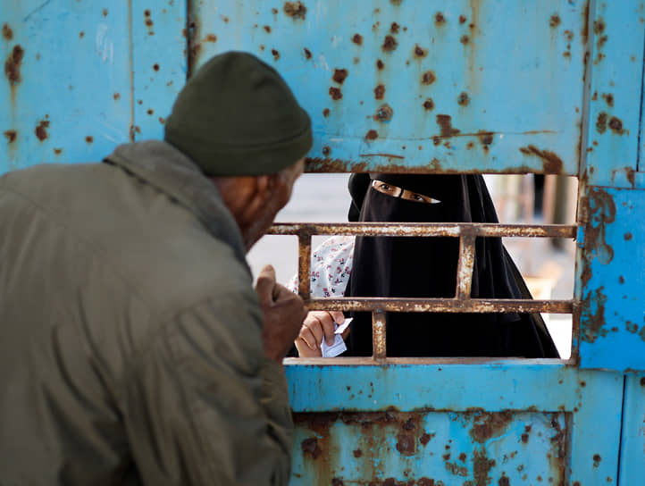 Газа, Палестина. Женщина из лагеря беженцев ждет продукты питания в центре распределения помощи