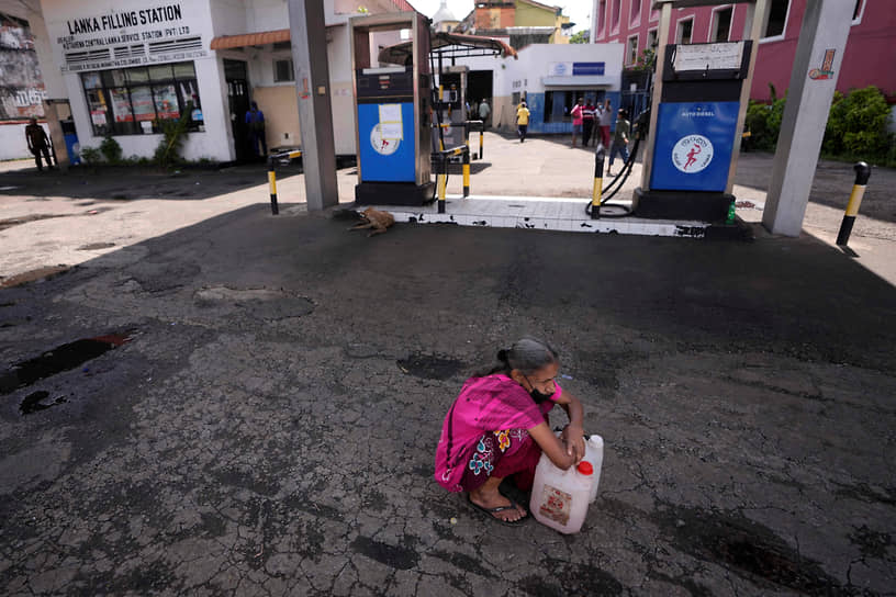 Коломбо, Шри-Ланка. Местная жительница на пустой заправке ждет возможности купить керосин