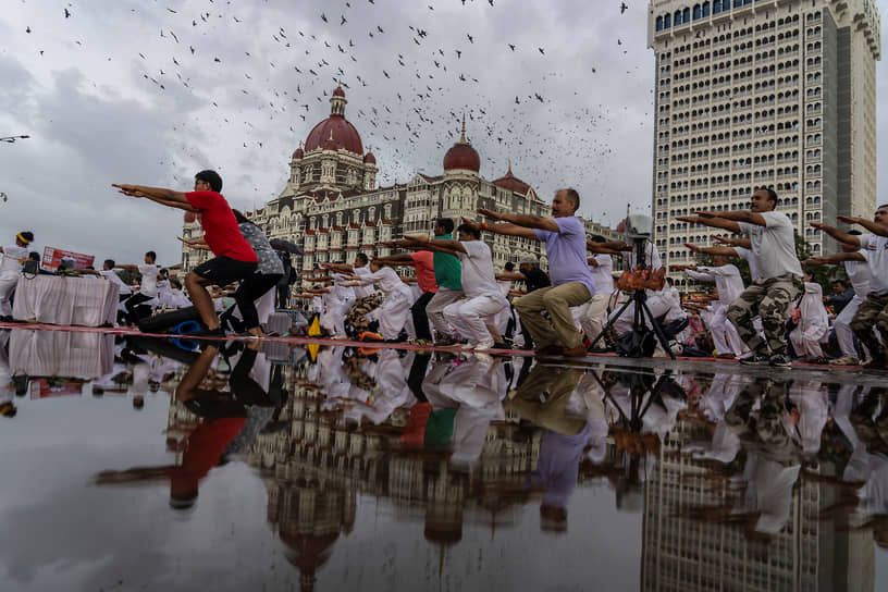 Мумбаи, Индия. Люди занимаются йогой в честь Международного дня йоги перед отелем Тадж-Махал Палас
