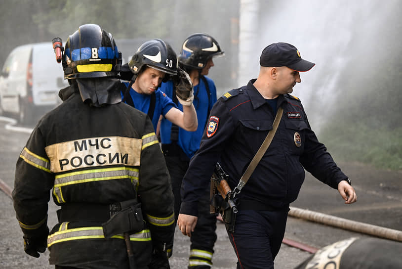 Площадь пожара составила около 2 тыс. кв. м. 
&lt;BR>На фото: сотрудники МЧС и полиции на месте происшествия 