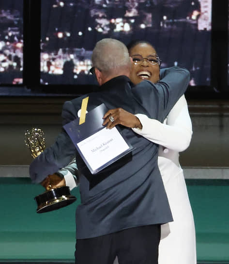 Телеведущая Опра Уинфри вручает Майклу Китону награду на сцене Театра Microsoft