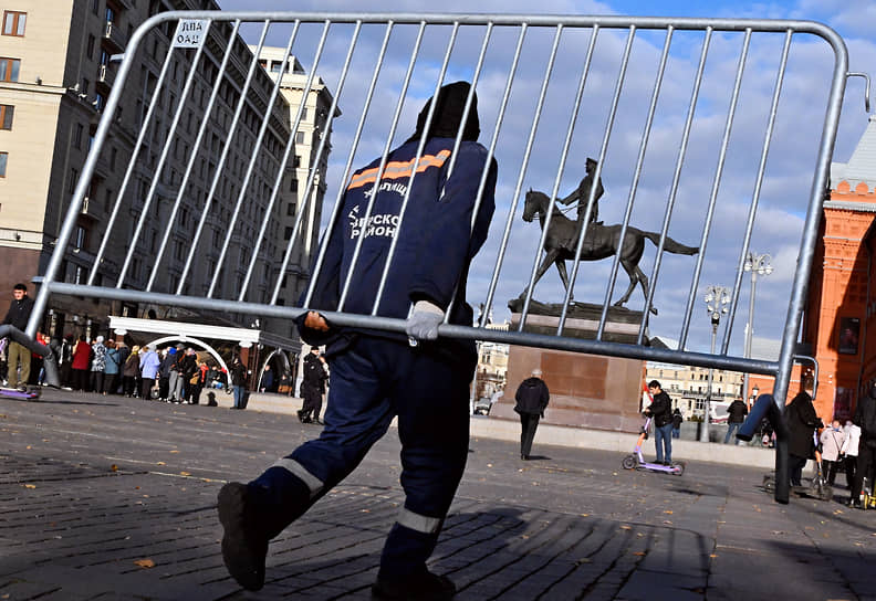 Москва. Сотрудник коммунальных служб переносит ограждение на Манежной площади